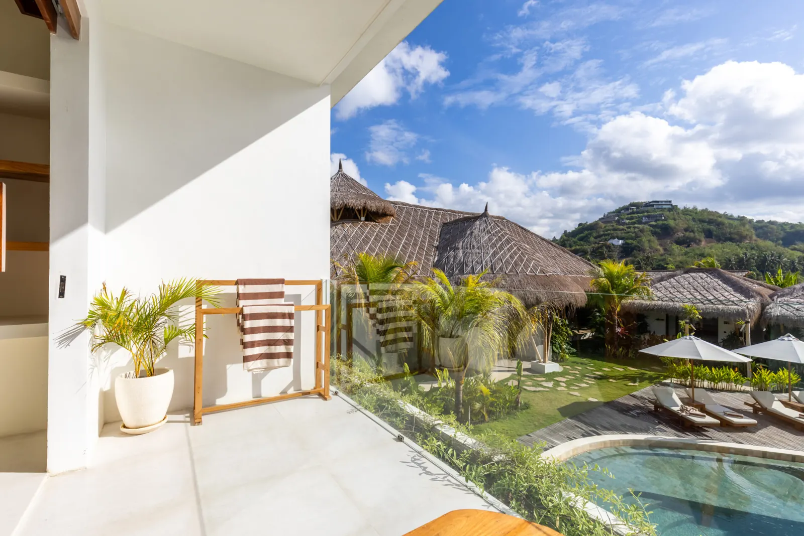 Terrace looking over the pool, thatched roofs and hills