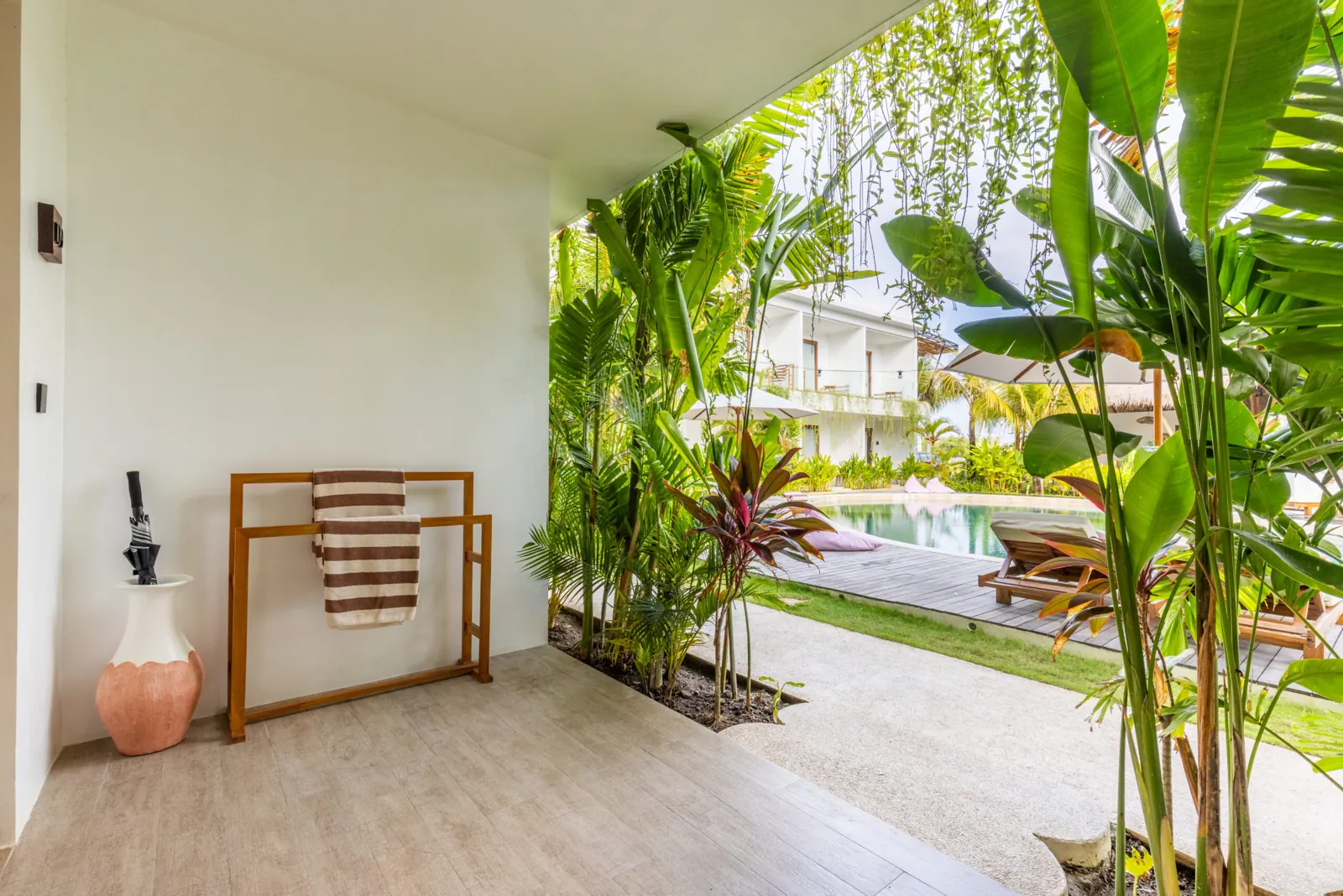Terrace with towel rail and plants, opening onto the pool garden